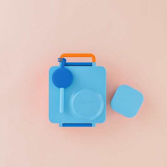 Blue lunch box with orange handle on a pink background