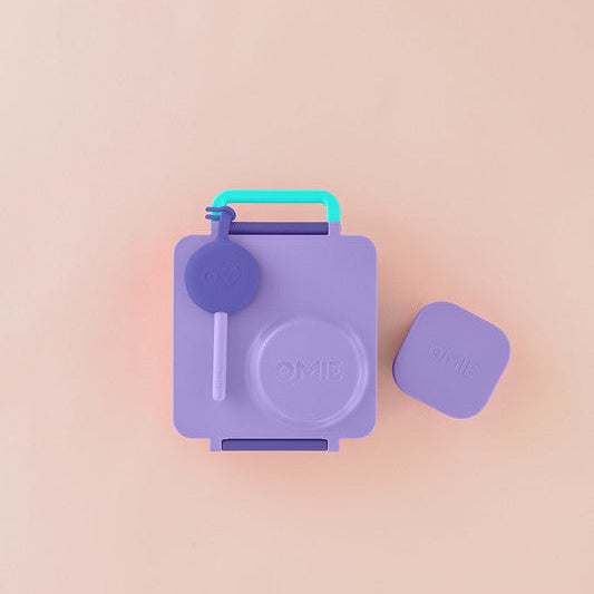 Purple snack container with a blue handle and lid on a pink background