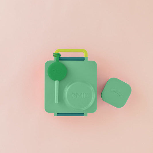 Green OMIE lunchbox with green lid on a pink background