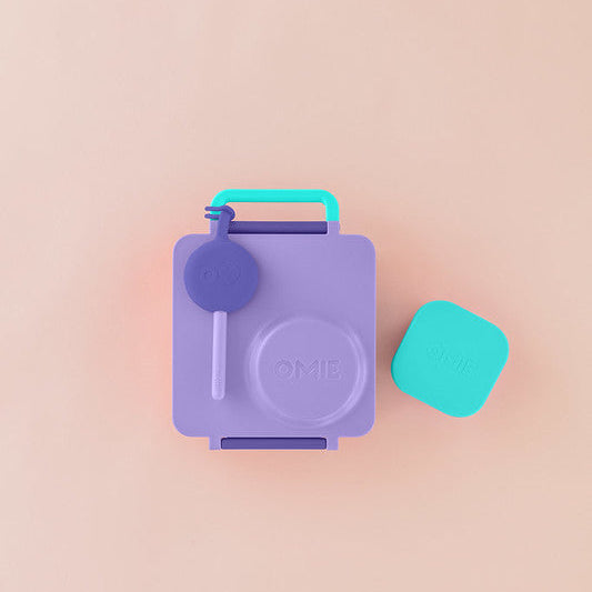 Purple and teal container with a lid on a pink background