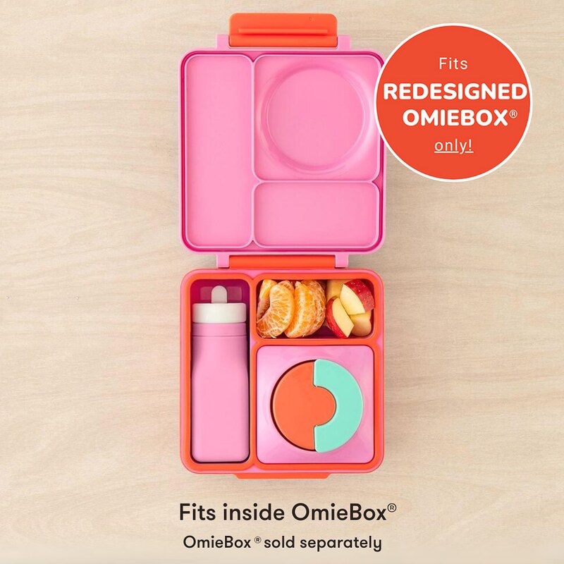 Pink and orange bento box with compartments filled with snacks on a beige background