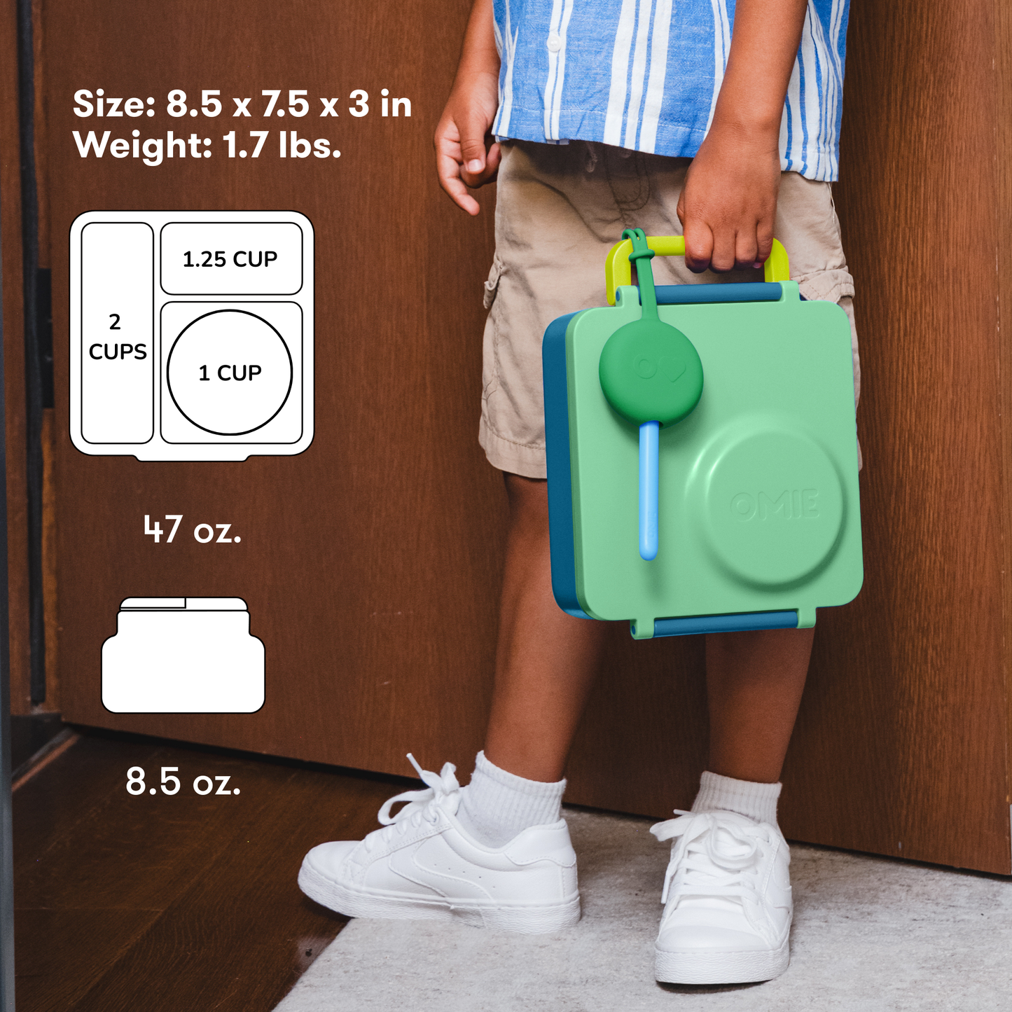 Green lunch box held by a child in front of a wooden door.