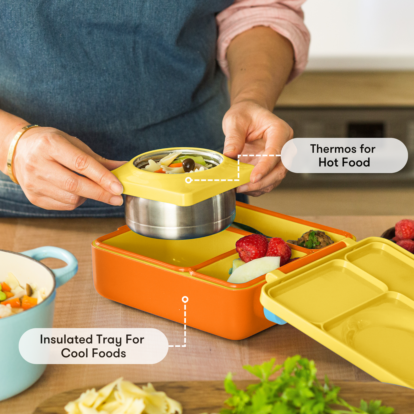 Person using a lunch box with a thermos for hot food and an insulated tray for cool foods.