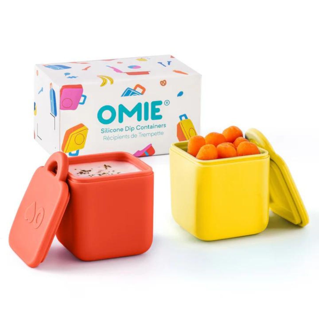 Two silicone dip containers in blue and green colors with the OmieDip brand logo on the lid, displayed next to their packaging box.