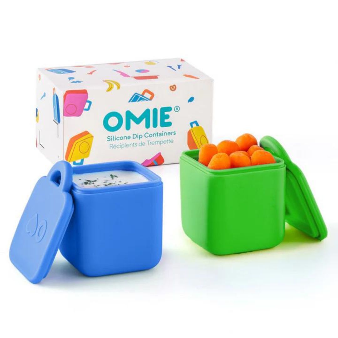 Two silicone dip containers in blue and green colors with the OmieDip brand logo on the lid, displayed next to their packaging box.