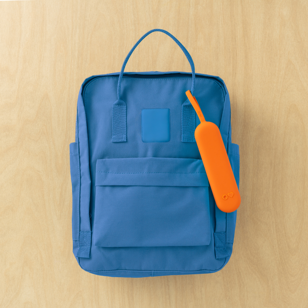 Blue backpack with an orange tag on a wooden surface