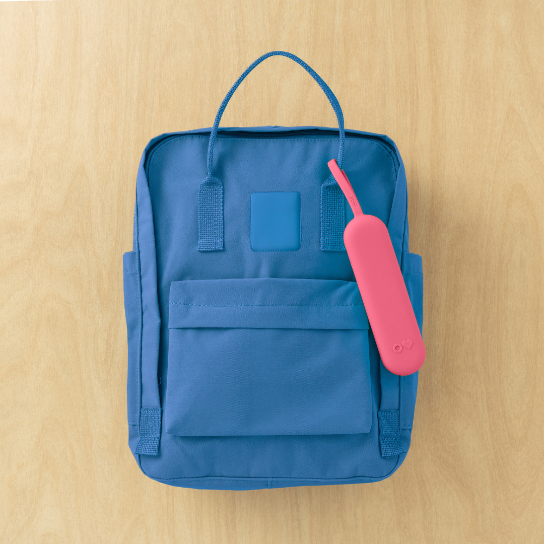 Blue backpack with a pink item on a wooden surface
