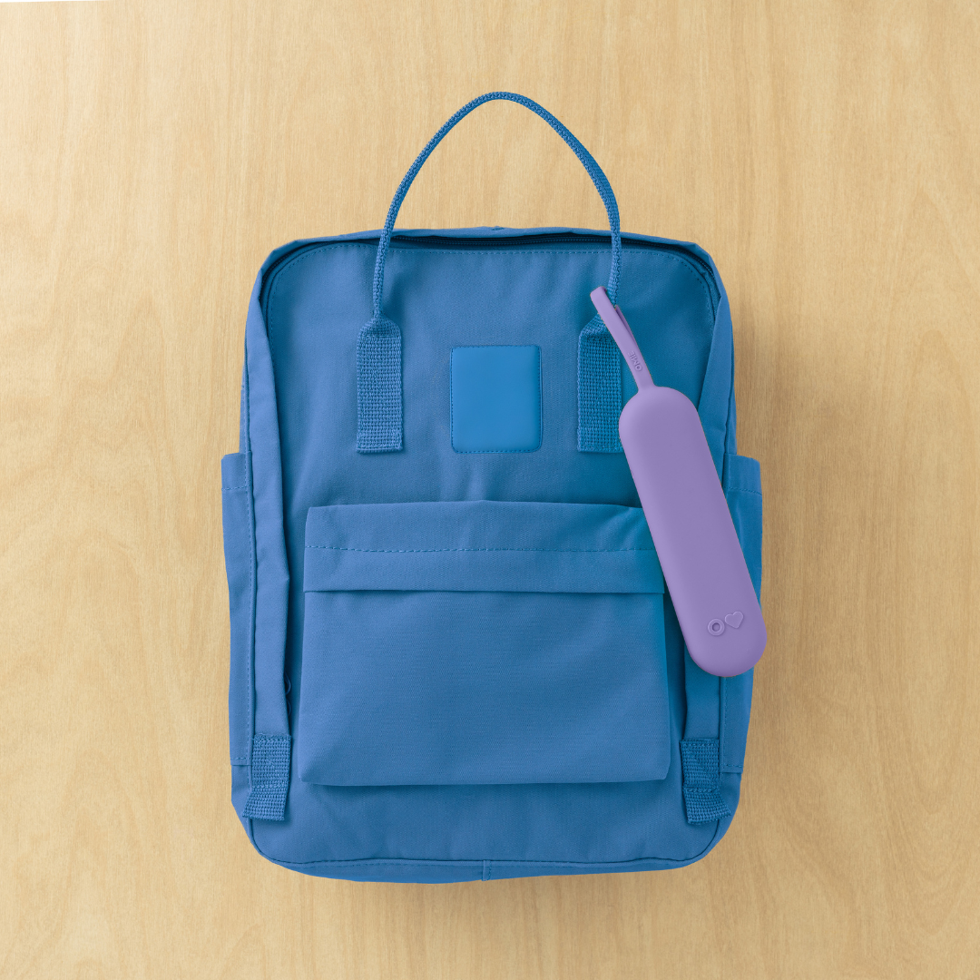 Blue backpack with a purple item on a wooden surface