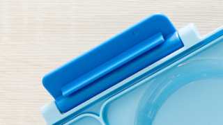 A blue replacement latch for the OmieBox food storage container.