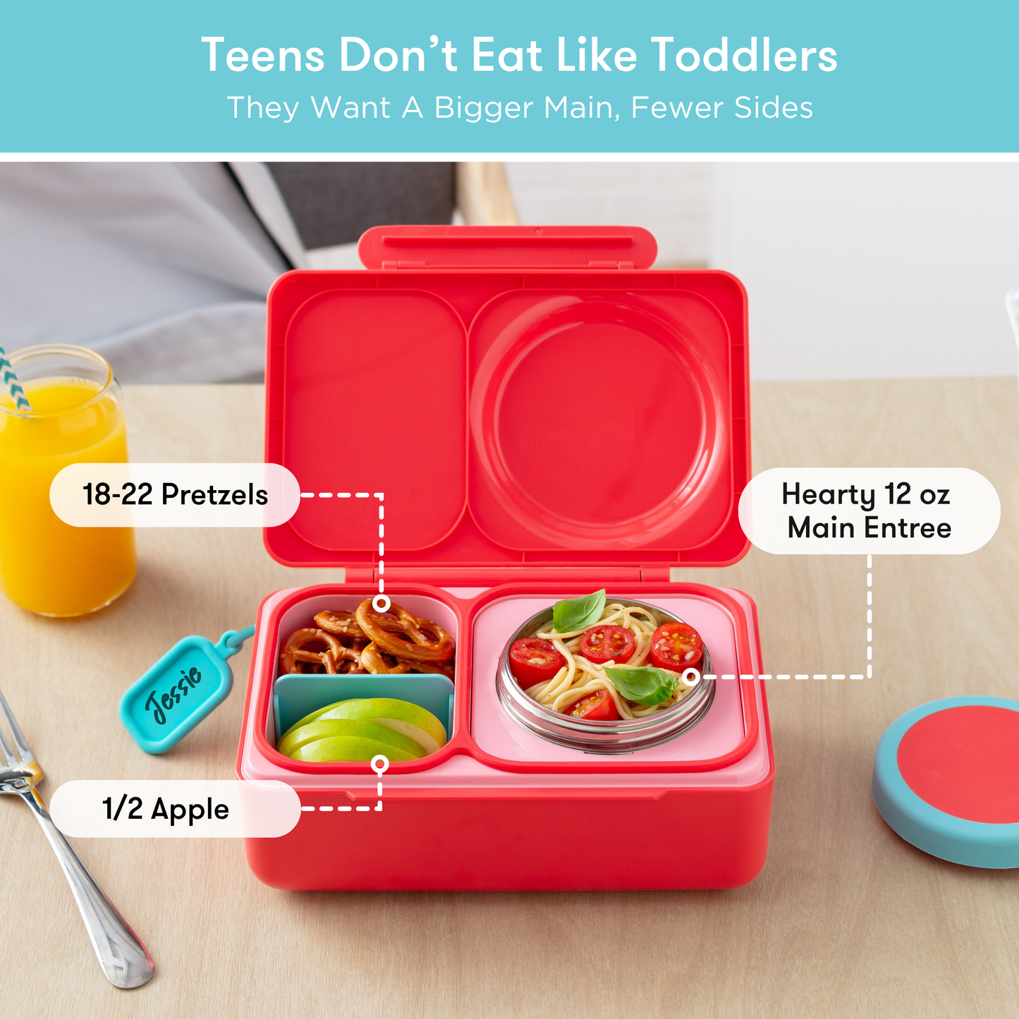 Red bento box with compartments labeled for food items on a table.