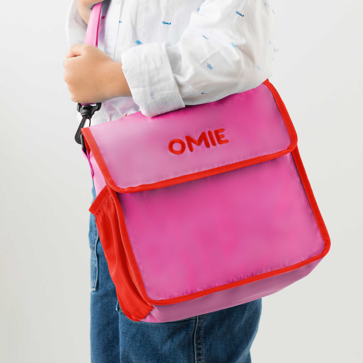 Pink bag with red trim held by a person on a white background