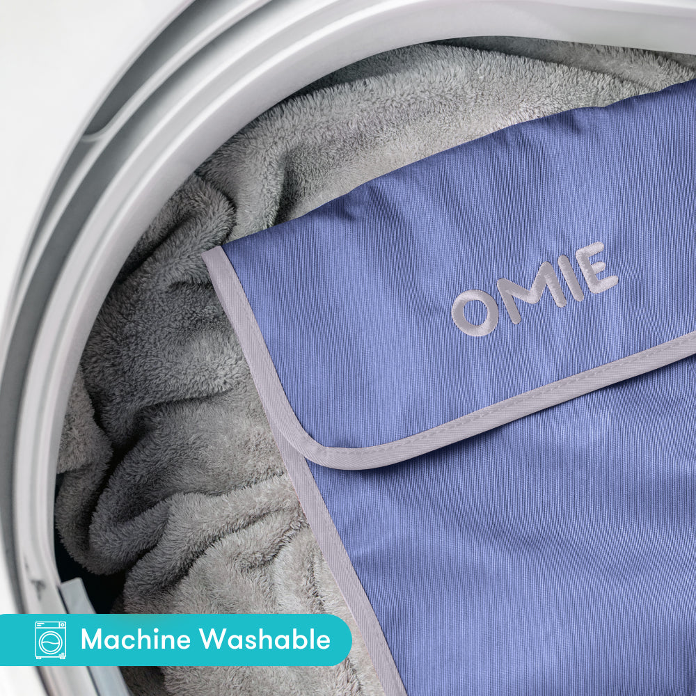 Blue OMIE product inside a washing machine with 'Machine Washable' label.
