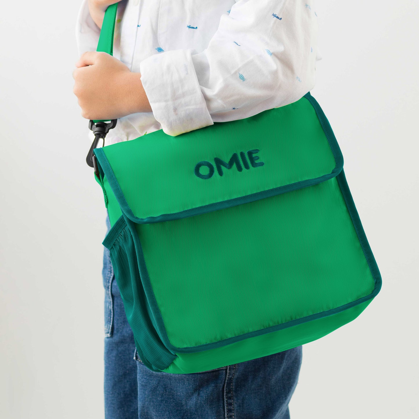 Green bag with 'OMIE' branding held by a person on a white background