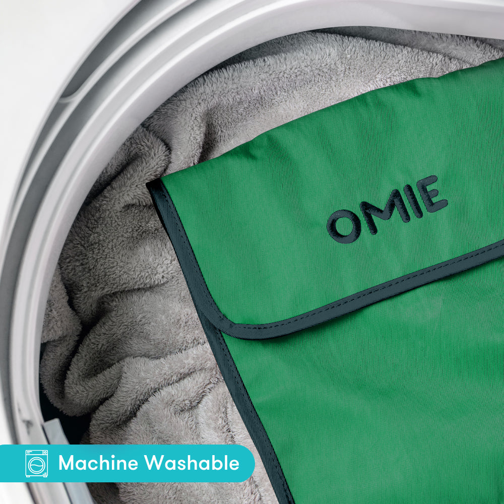 Green OMIE product inside a washing machine with 'Machine Washable' label.
