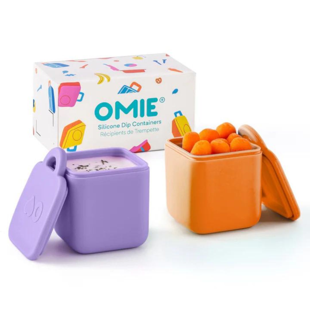 Two silicone dip containers in blue and green colors with the OmieDip brand logo on the lid, displayed next to their packaging box.