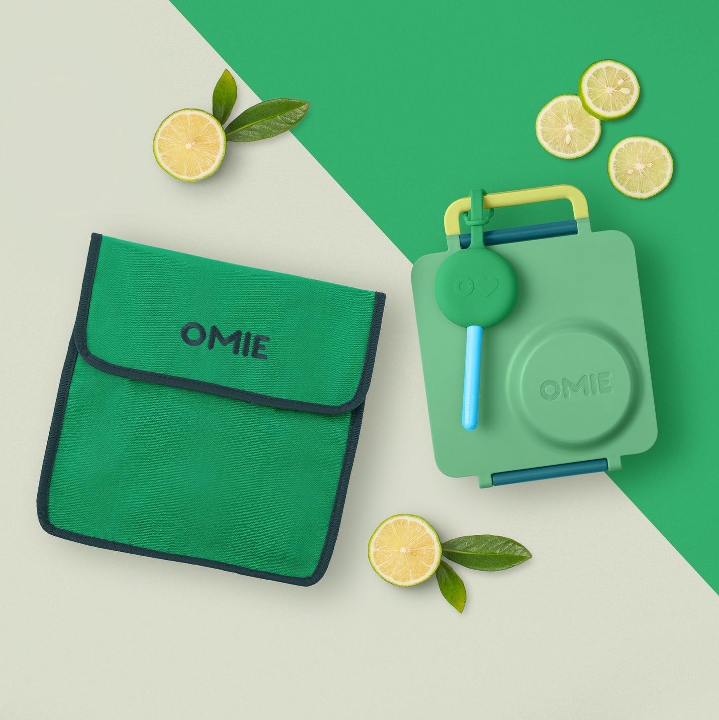 Green OMIE lunch bag and container with lemon slices on a green and beige background