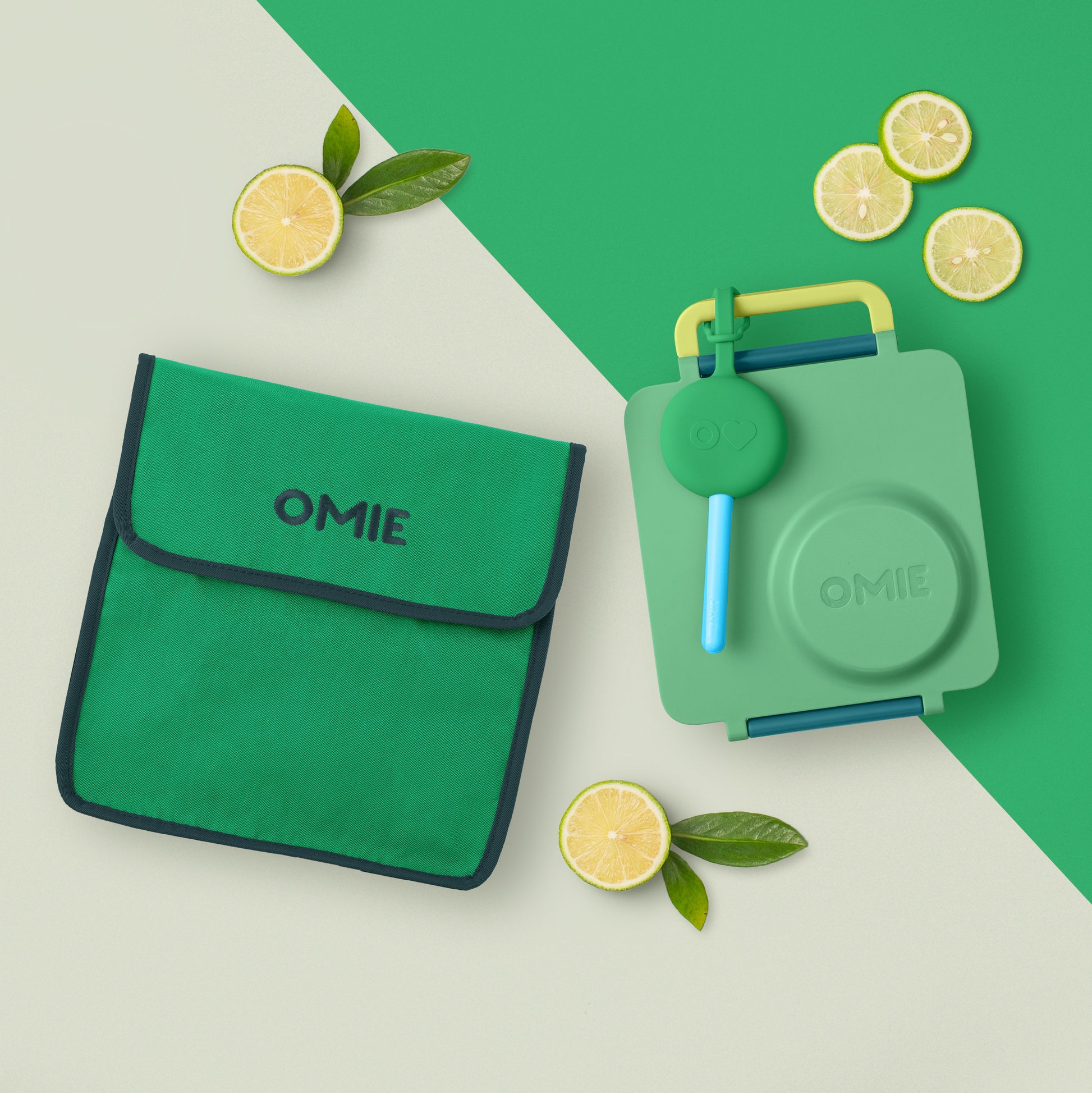 Green OMIE lunch bag and container with lemon slices on a green and beige background